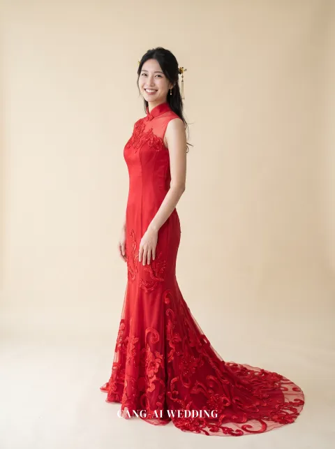Front full-length of Ruyi, a red satin mermaid kua with a mandarin collar and embroidered scrolls, turning back to the camera with a smile, reference 17-NR486.