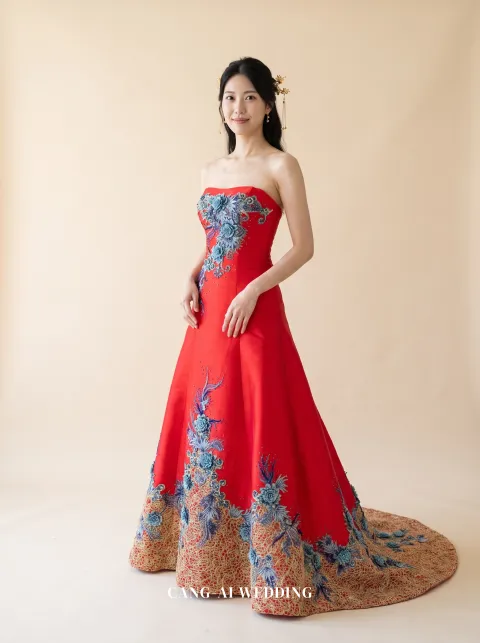 Front full-length of Yunqi, a strapless red A-line with blue and gold floral work from hem to bodice, reference 12-NR65.
