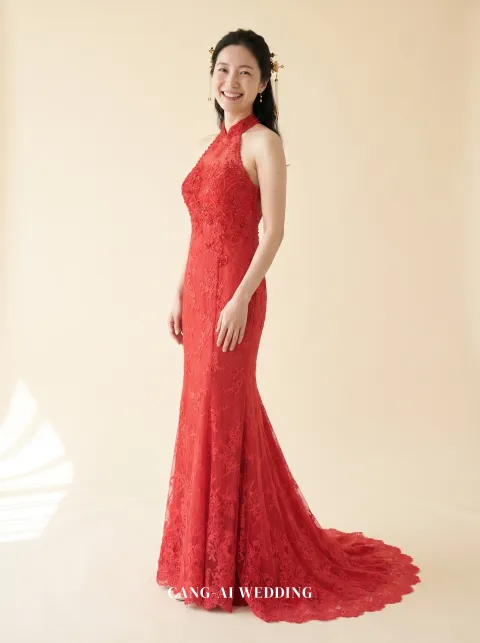 Front full-length of Chujian, a red corded lace halter mermaid gown, turning back to the camera with a smile, reference R59.