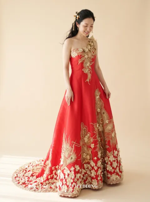 Front full-length of Luoying, a one-shoulder red A-line gown with gold blossom, looking down at the skirt, reference 5-NR09-1.