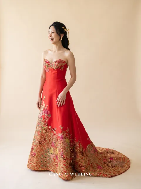 Front full-length of Fanhua, a strapless red A-line with rose and gold blossom on the lower skirt, laughing and looking away, reference 10-NR30.