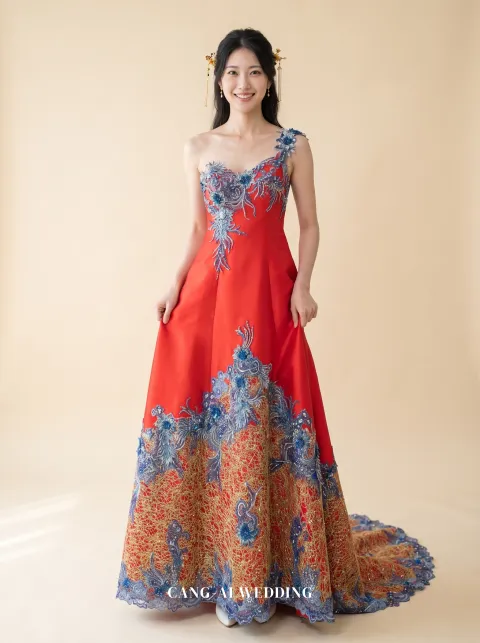 Front full-length of Qingniao, a one-shoulder red A-line with blue beadwork, lifting the skirt slightly at the hips, reference 8-NR15.
